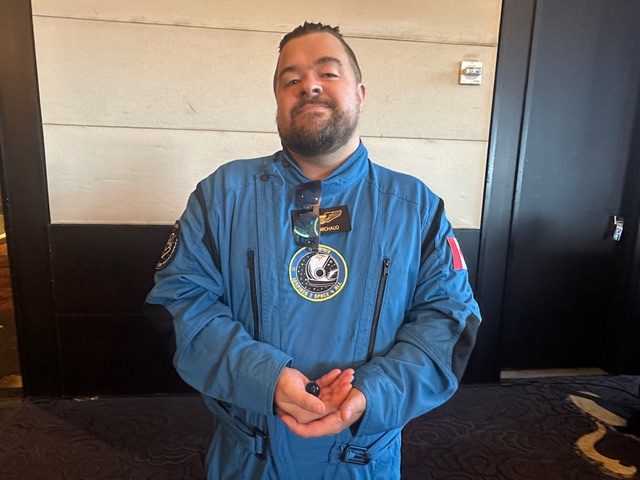 Jason Michaud in a blue flight suit